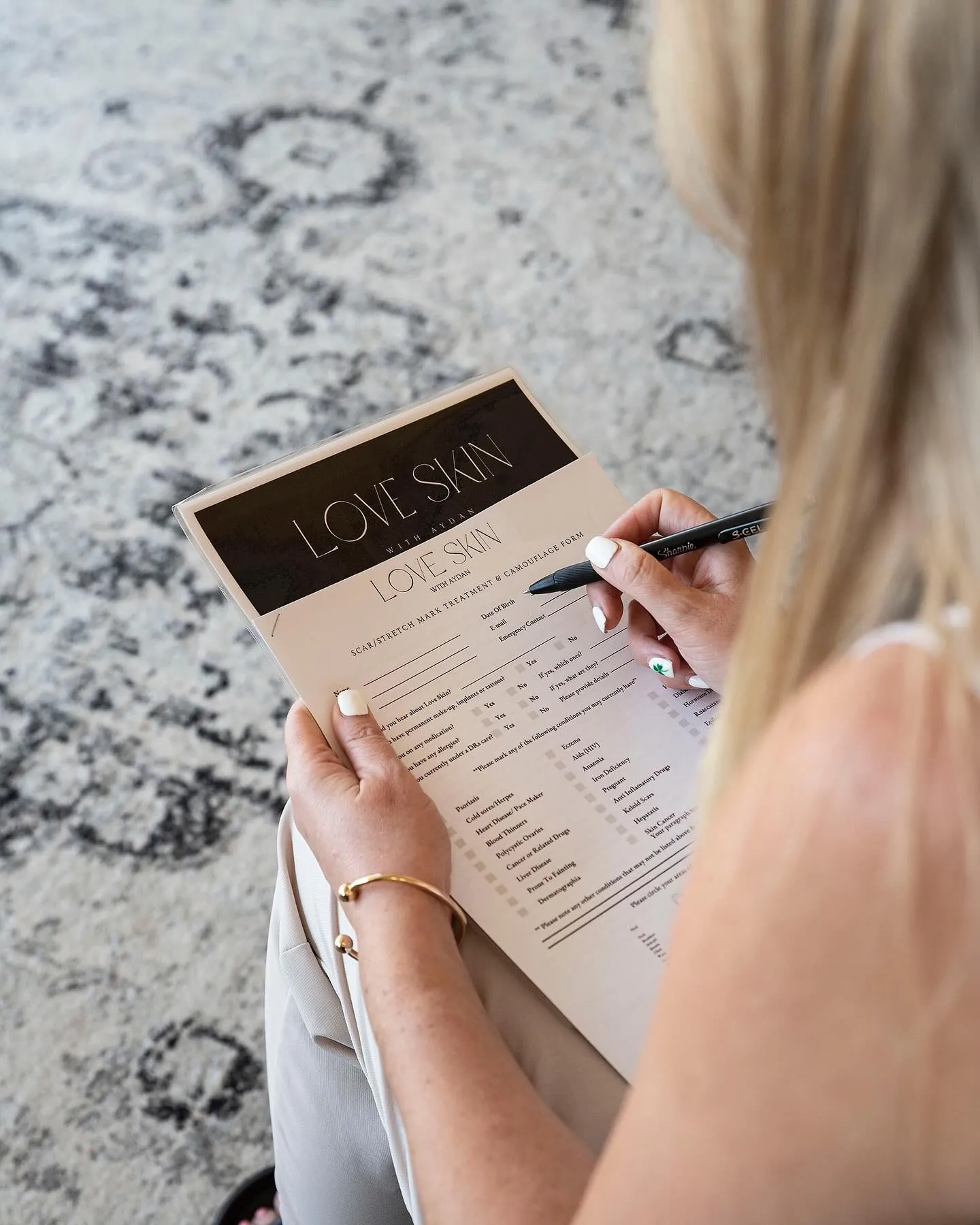 Client completing a consultation form at Love Skin With Aydan