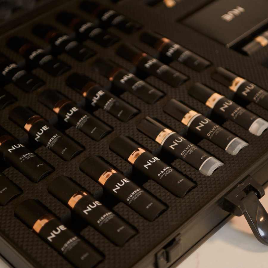 A black case containing multiple shades of NUEL foundation sticks arranged in rows. I Stretch Mark & Scar Treatment Perth Clinic